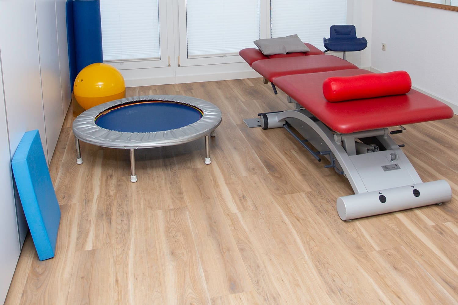 Behandlungszimmer mit Liege und Trampolin